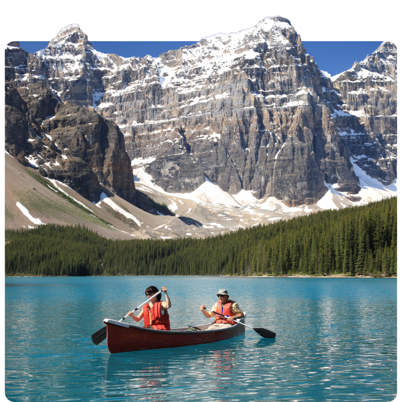 A couple canoeing in a scenic mountain area on a beautiful lake